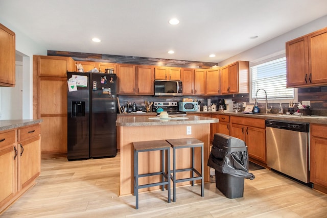 15000 Tiara Ave, Monroe, MI 48161 - kitchen featuring light wood finished floors, a center island, stainless steel appliances, and a sink