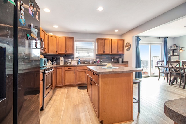 15000 Tiara Ave, Monroe, MI 48161 - kitchen with a healthy amount of sunlight, stainless steel appliances, a breakfast bar area, and a center island