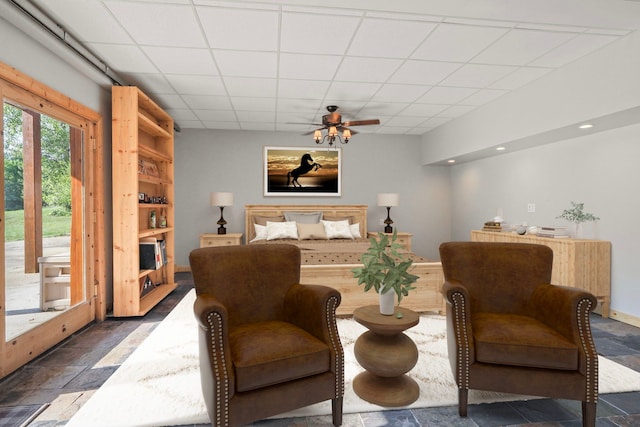 bedroom with stone tile flooring, recessed lighting, a paneled ceiling, and access to exterior