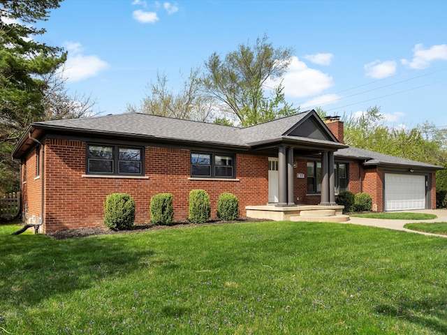 ranch-style home featuring brick siding, a garage, a chimney, and a front yard