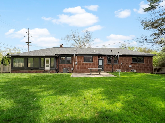 back of house with a patio, central air condition unit, brick siding, and a chimney