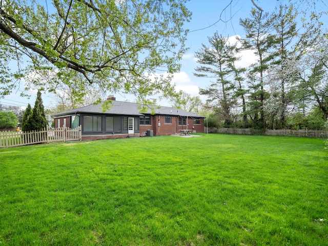 view of yard featuring a sunroom and central AC unit