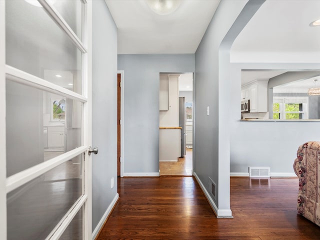 hallway featuring wood finished floors and baseboards