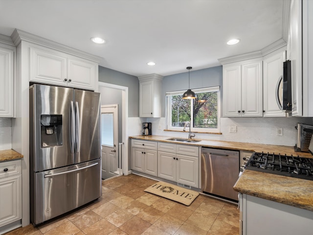 kitchen featuring appliances with stainless steel finishes, a sink, backsplash, white cabinets, and recessed lighting