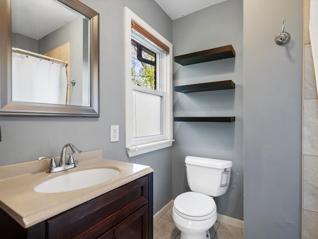 bathroom with toilet, vanity, baseboards, and tile patterned floors
