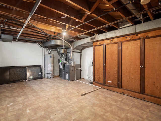 unfinished basement featuring gas water heater, heating unit, and tile patterned floors