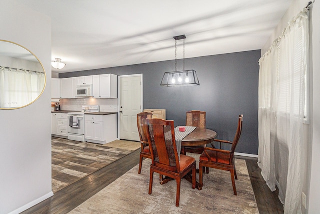 dining space with baseboards and dark wood-style flooring