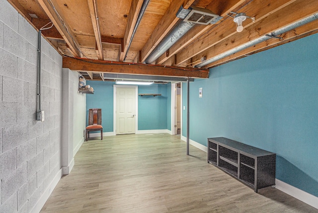 finished basement featuring baseboards, visible vents, and wood finished floors