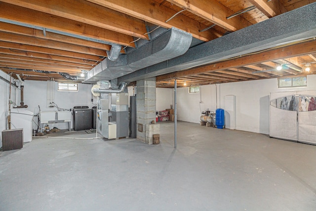below grade area with heating unit, washing machine and dryer, a sink, and a wealth of natural light