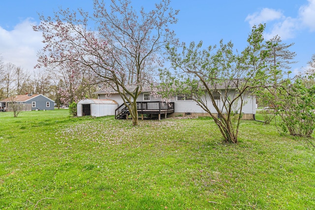 view of yard featuring a storage unit, a wooden deck, and an outdoor structure