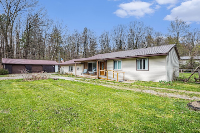 view of front of home featuring covered porch, metal roof, and a front lawn