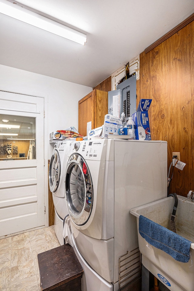 washroom featuring a sink, cabinet space, electric panel, and washer and dryer