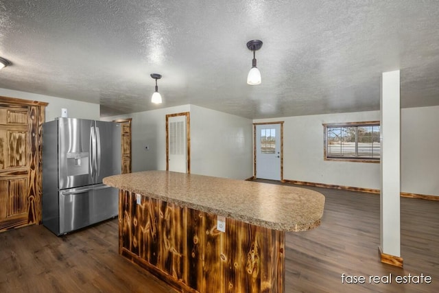 4731 N Osborn Rd, Riverdale, MI 48877 - kitchen featuring stainless steel refrigerator with ice dispenser, a textured ceiling, a kitchen island, and dark wood-style floors