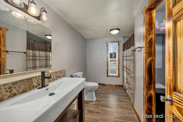 4731 N Osborn Rd, Riverdale, MI 48877 - bathroom featuring vanity, toilet, baseboards, curtained shower, and wood tiled floor