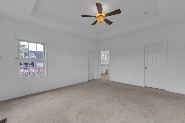 9080 Emerson Dr, Saline, MI 48176 - unfurnished bedroom with carpet flooring, ensuite bath, a tray ceiling, and multiple windows