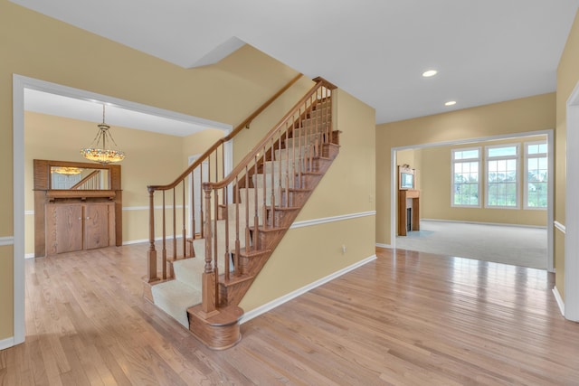 9080 Emerson Dr, Saline, MI 48176 - stairway with baseboards, an inviting chandelier, and wood finished floors
