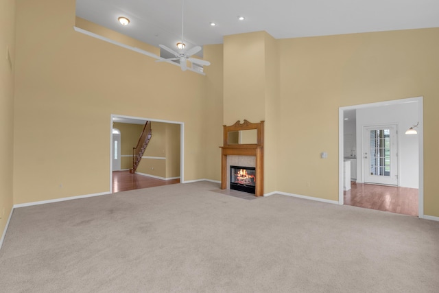 9080 Emerson Dr, Saline, MI 48176 - unfurnished living room with baseboards, a fireplace with flush hearth, carpet, and a towering ceiling