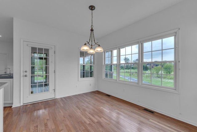 9080 Emerson Dr, Saline, MI 48176 - unfurnished dining area with visible vents, a sink, a chandelier, and a healthy amount of sunlight