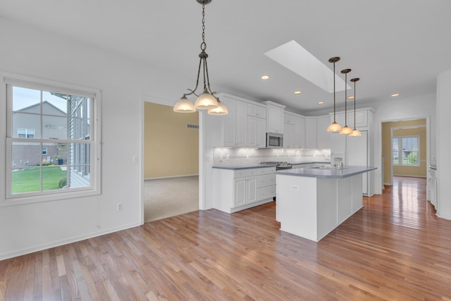 9080 Emerson Dr, Saline, MI 48176 - kitchen with a sink, light wood-style flooring, white cabinetry, and stainless steel microwave