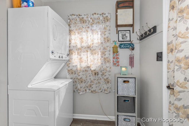 laundry room featuring stacked washer and dryer, laundry area, and baseboards