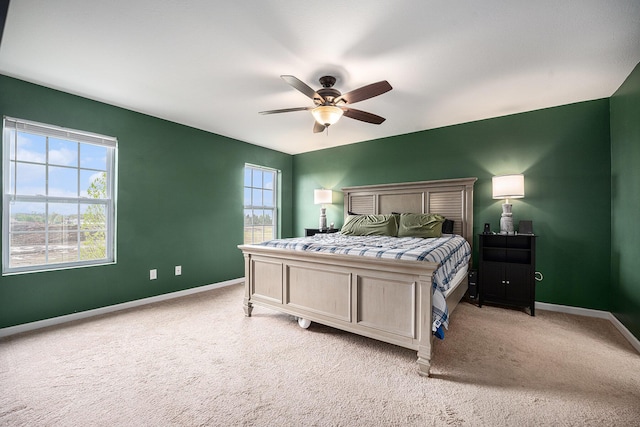 bedroom with baseboards, ceiling fan, and light colored carpet