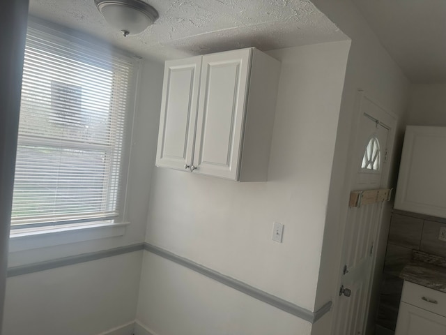 washroom with baseboards and a textured ceiling