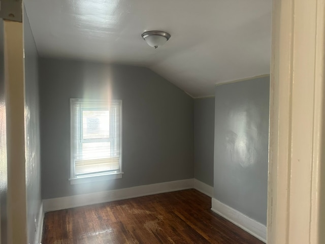 bonus room featuring dark wood-style flooring, baseboards, and lofted ceiling