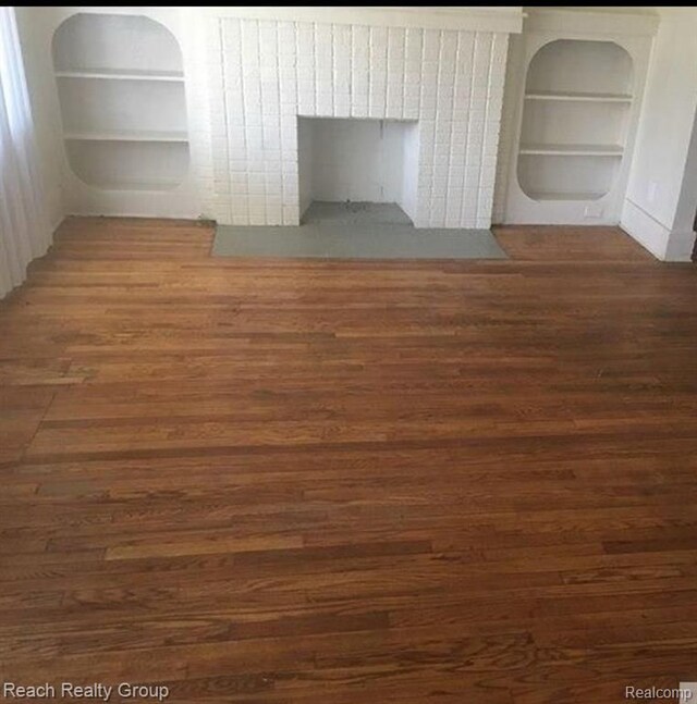 interior space featuring built in features, wood finished floors, and a fireplace