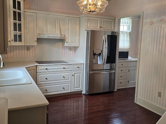 kitchen with wallpapered walls, a sink, and stainless steel appliances