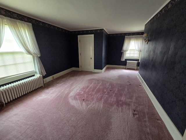 unfurnished bedroom featuring carpet floors, baseboards, and radiator heating unit