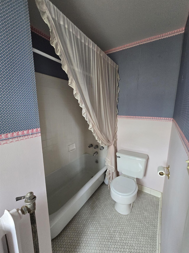 bathroom featuring shower / tub combo and toilet