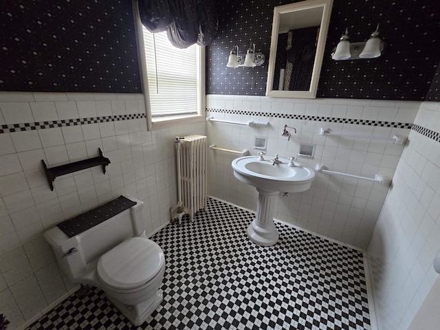 bathroom with radiator heating unit, a wainscoted wall, toilet, and wallpapered walls