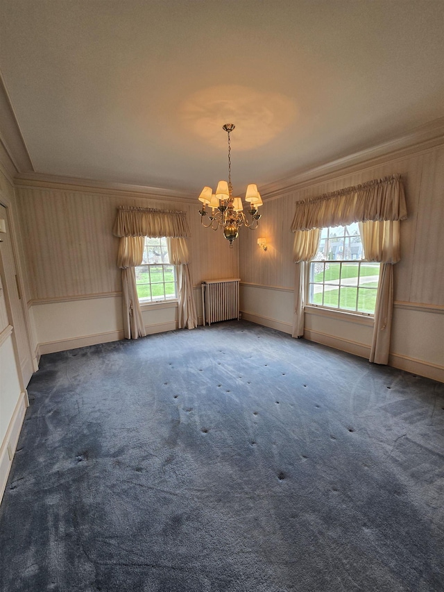 carpeted empty room featuring an inviting chandelier, ornamental molding, radiator, and baseboards