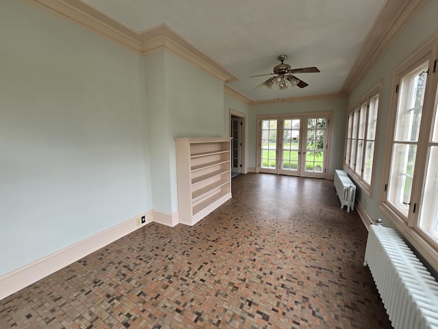 interior space with baseboards, a ceiling fan, crown molding, and radiator heating unit