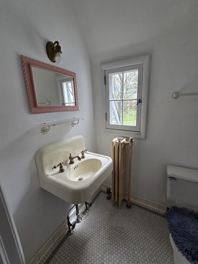 half bath featuring toilet, vaulted ceiling, and radiator heating unit