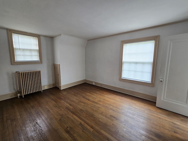 unfurnished room featuring baseboards, radiator, and dark wood-style floors