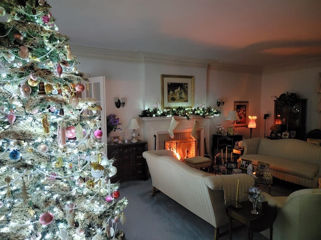 carpeted living room with crown molding and a warm lit fireplace