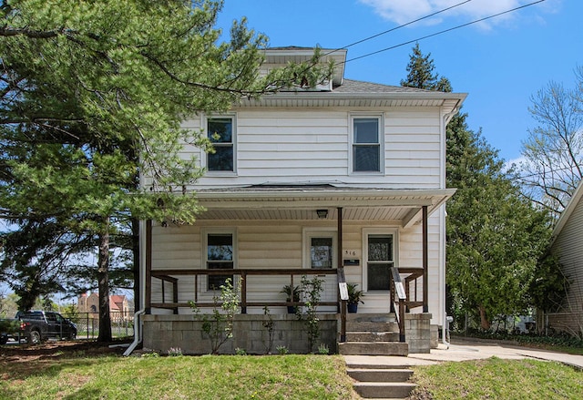 traditional style home featuring roof with shingles, fence, a porch, and a front yard