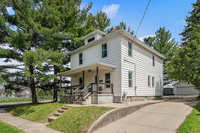 american foursquare style home featuring an outdoor structure, a chimney, covered porch, and a front yard