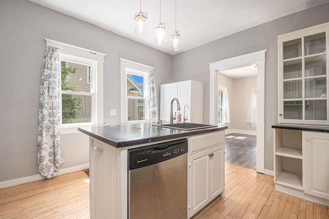 kitchen featuring baseboards, a sink, light wood-style flooring, and dishwasher