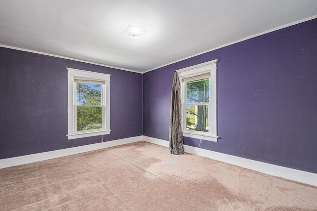 unfurnished room with baseboards, carpet flooring, a healthy amount of sunlight, and ornamental molding