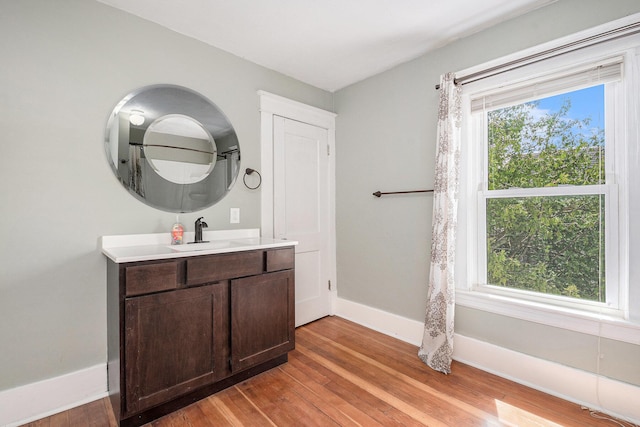 bathroom featuring baseboards, wood finished floors, and vanity