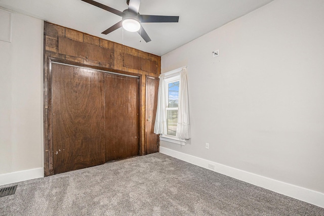 unfurnished bedroom featuring carpet flooring, ceiling fan, baseboards, visible vents, and a closet