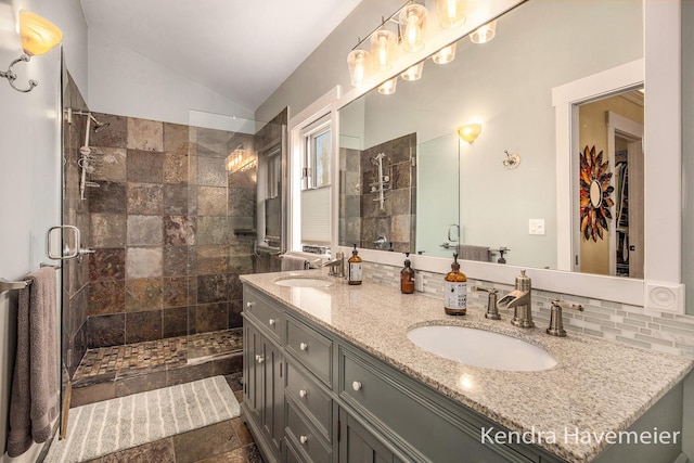 bathroom with vaulted ceiling, a shower stall, and a sink
