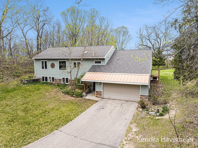 view of front of home featuring a garage, stone siding, a front yard, a shingled roof, and driveway