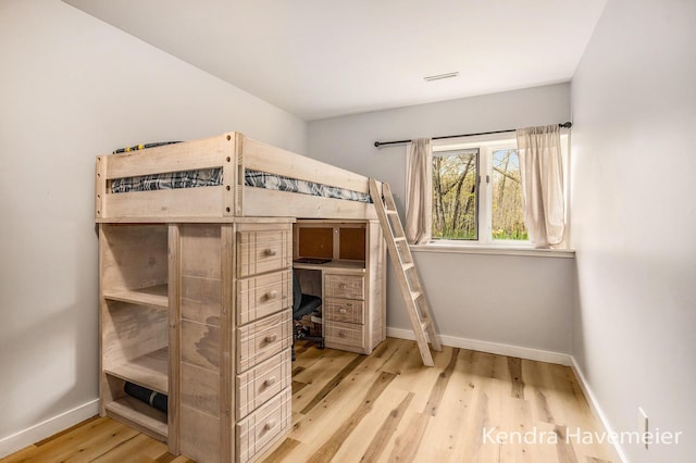 unfurnished bedroom with baseboards, visible vents, and wood finished floors