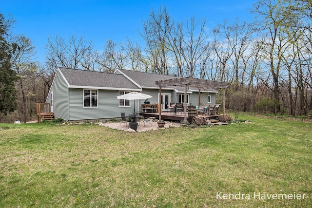back of house with roof with shingles, a pergola, a yard, and a deck