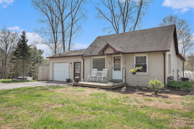 view of front of property featuring a shingled roof, driveway, a garage, and a front lawn