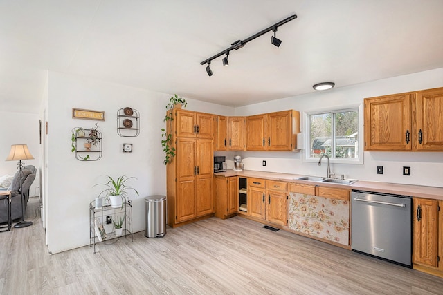 kitchen with dishwasher, light wood-type flooring, visible vents, and a sink