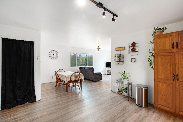 dining area with rail lighting and light wood-type flooring